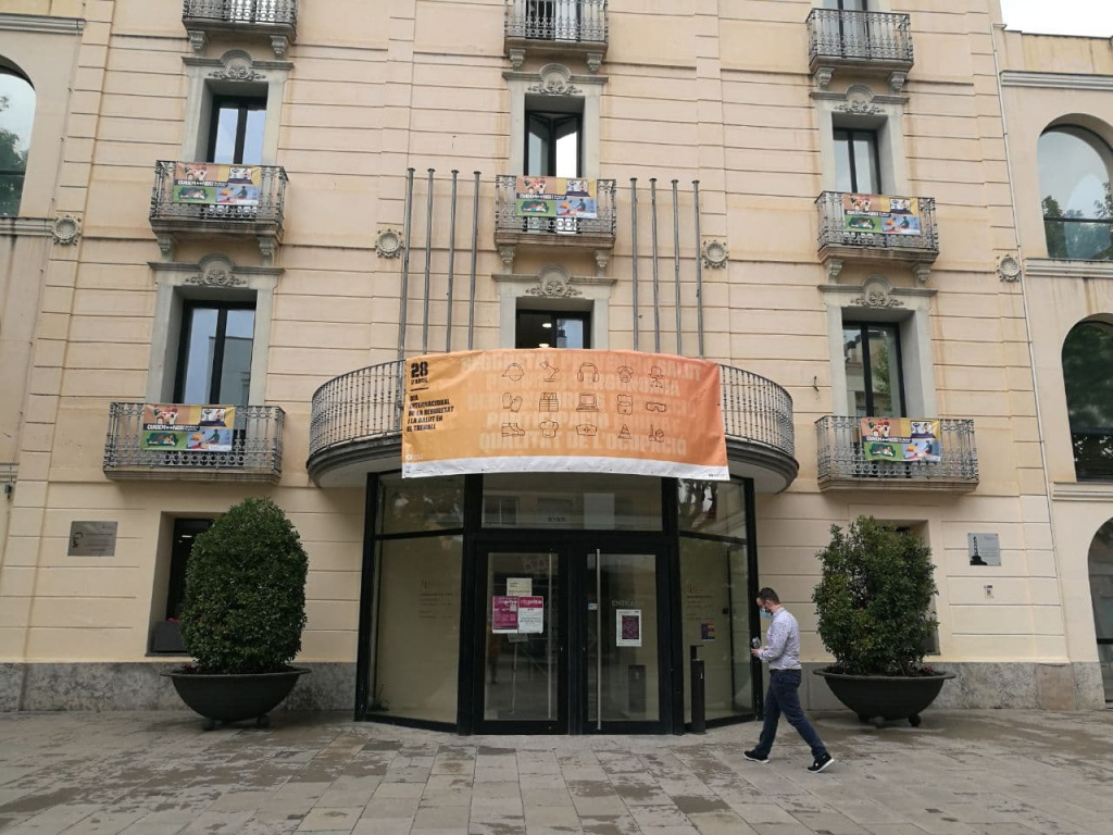 Façana de l'Ajuntament amb un cartell del dia Internacional de la Seguretat i la Salut en el Treball