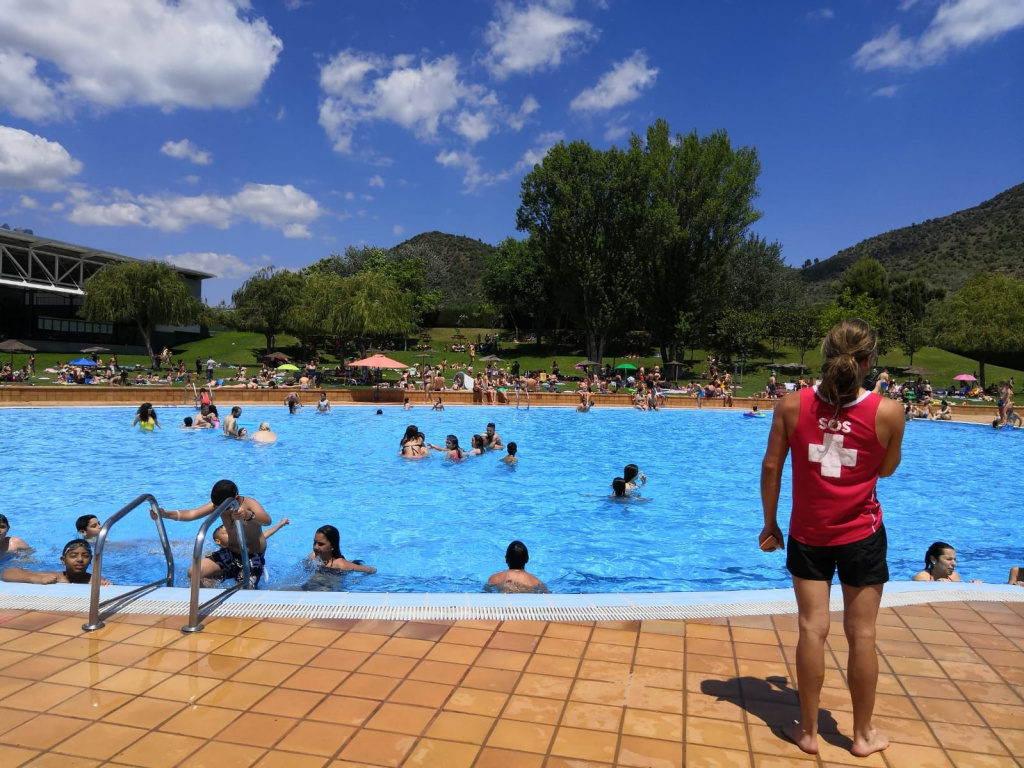 Piscina d'estiu plena de banyistes amb el socorrista vigilant