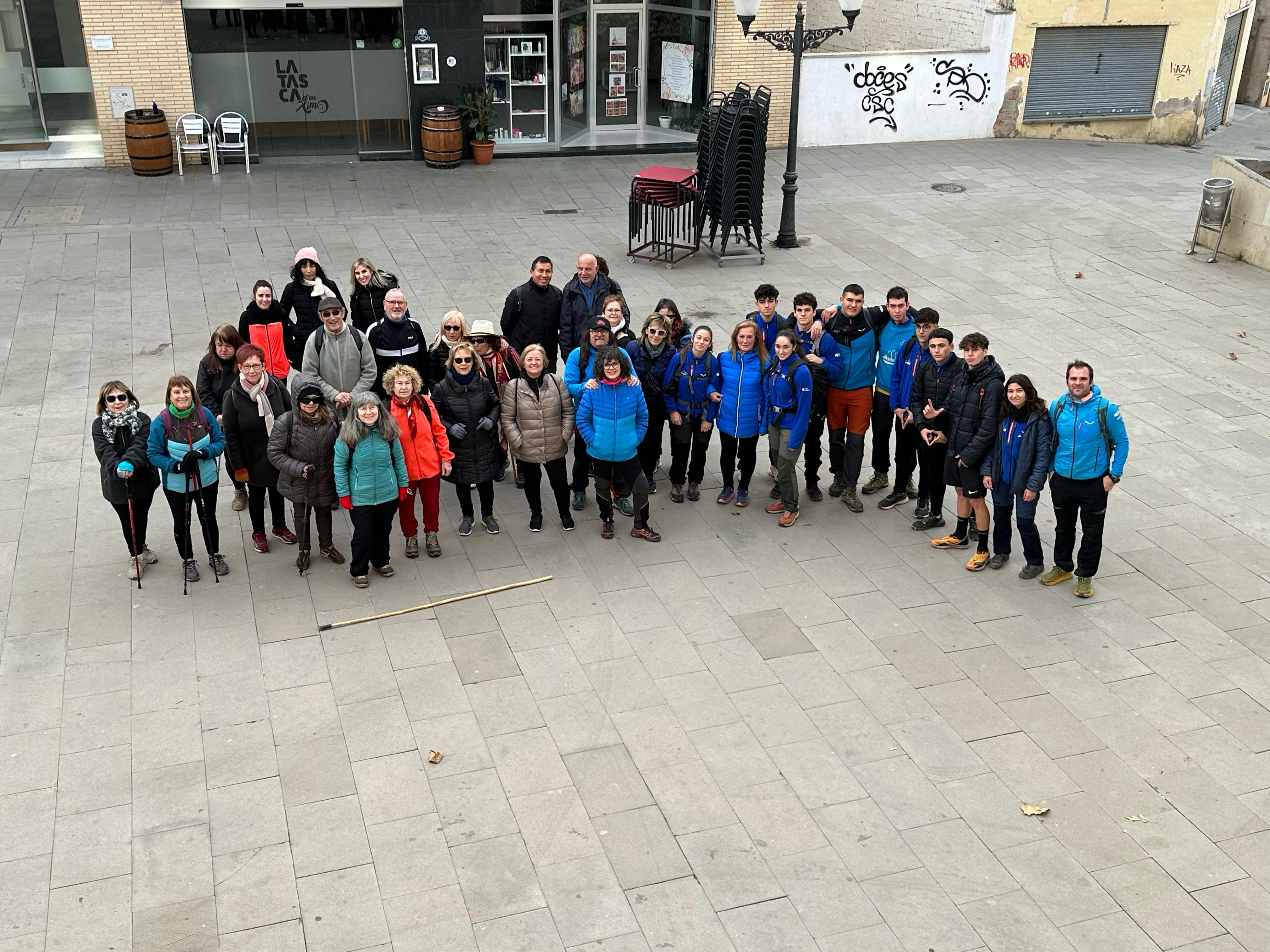 Grup de persones es preparen per a una sortida a l'entorn natural amb la col·laboració dels alumnes del cicle GUIAMN