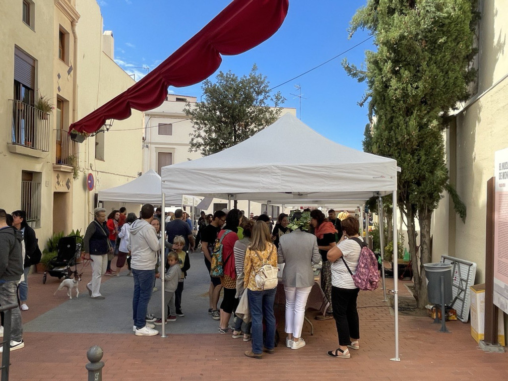 Gent mirant a les parades de productes d'artesania