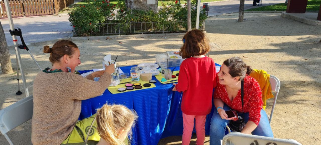 dues mares rient en una taula de pintura amb nenes