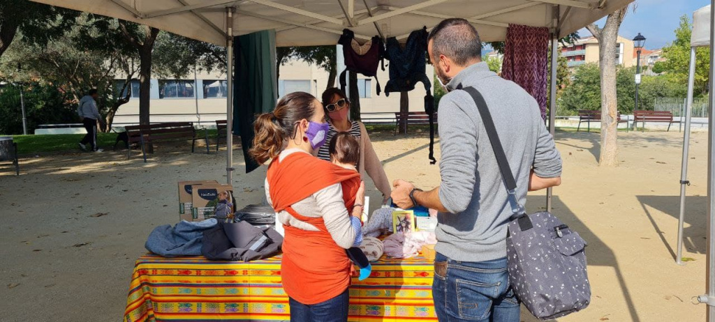 Persones en una parada amb motxilles per portar als nadons